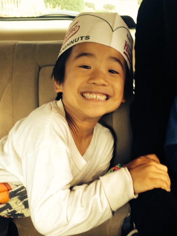 Aidan beaming in a paper hat