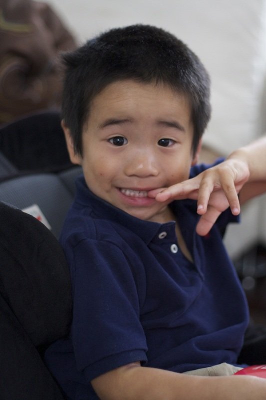 Aidan in a navy polo, smiling at the camera